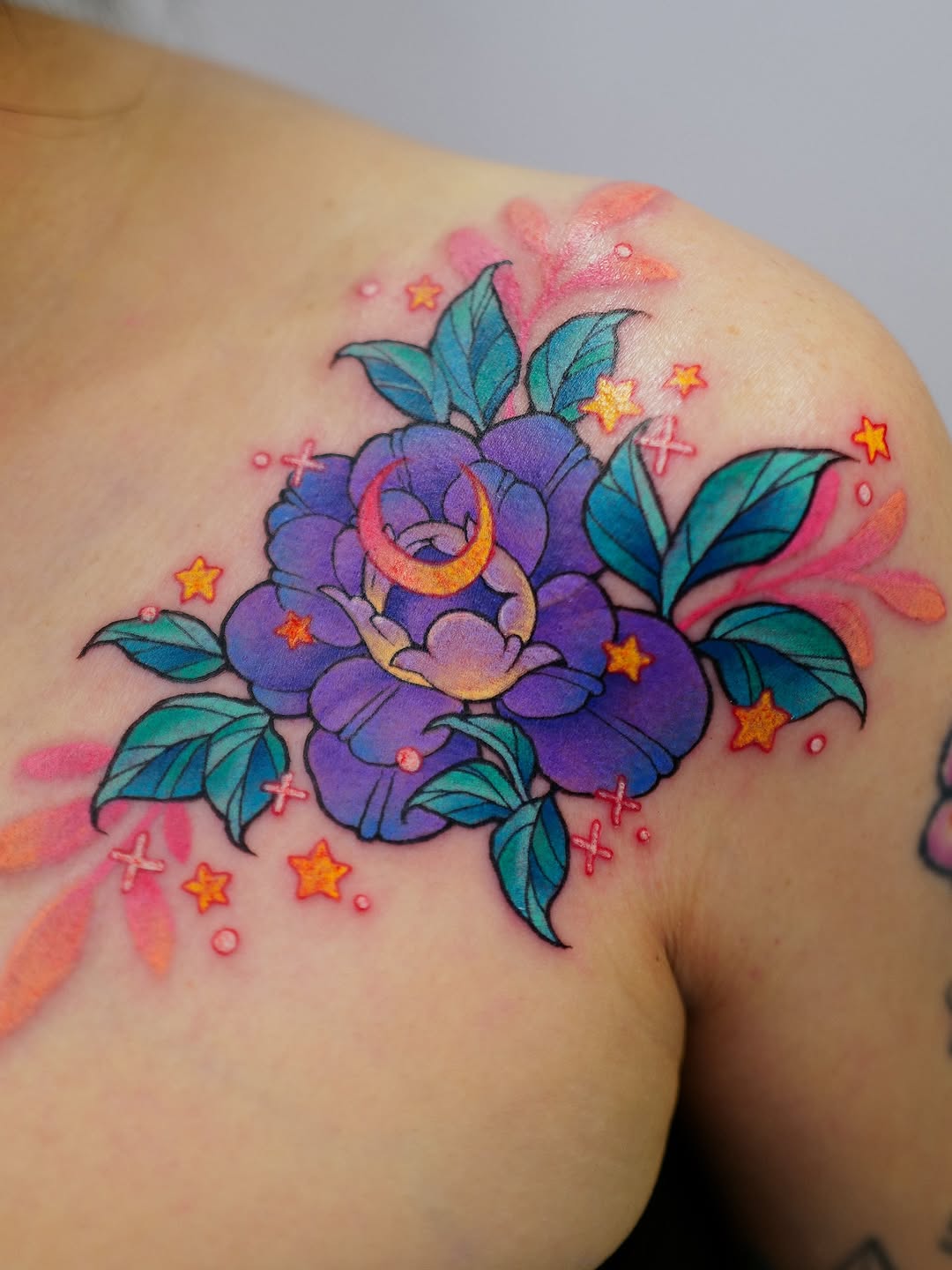 Purple flower with teal leaves and a crescent moon surrounded by gold and orange stars on the shoulder, with pink and coral watercolor effects.