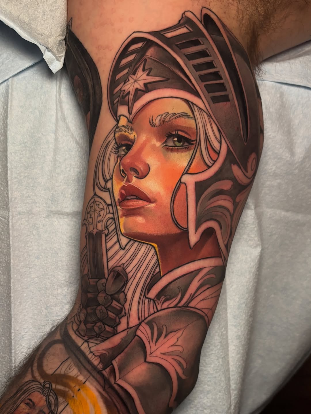 Colorful portrait tattoo of a woman wearing an ornate Egyptian headdress with a star symbol, featuring warm orange and brown tones on the upper leg.