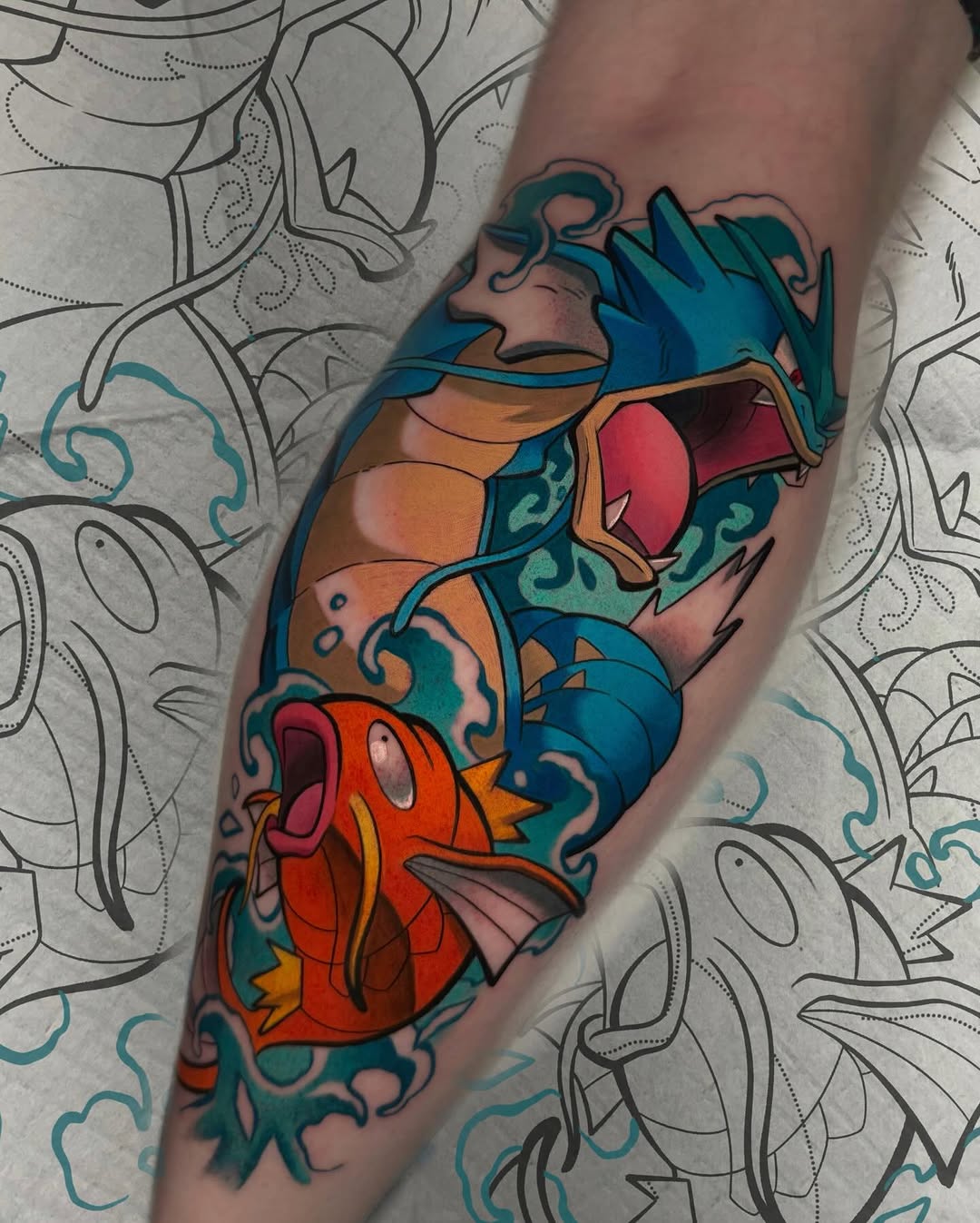 Colorful stacked fish tattoo on forearm featuring red, orange, blue, and teal with decorative swirling details between each fish.