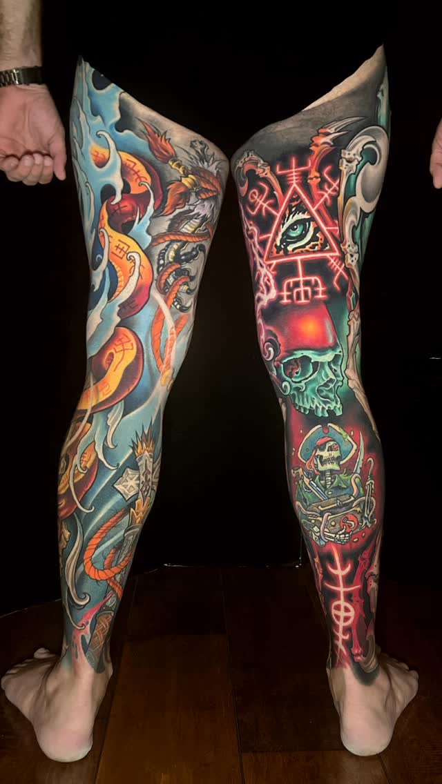 Full-leg tattoo sleeves featuring colorful dragons, mystical symbols, skulls, and neon glowing elements in red, orange, blue, and green on both legs.