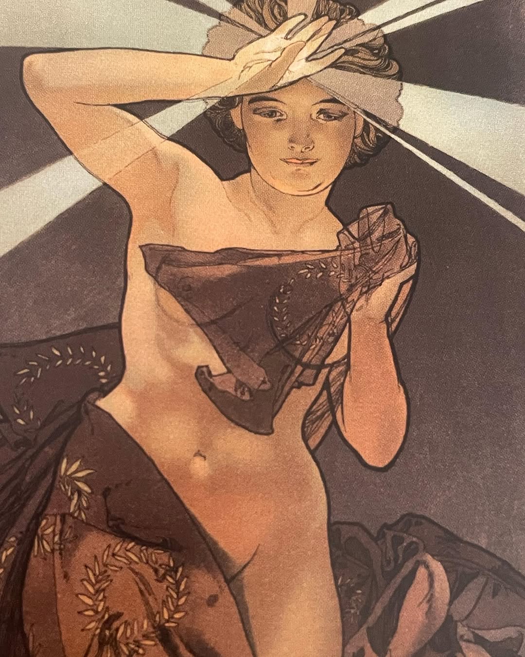 Vintage illustration of a woman wearing a wide-brimmed hat and draped fabric, rendered in sepia and brown tones with decorative leaf elements.