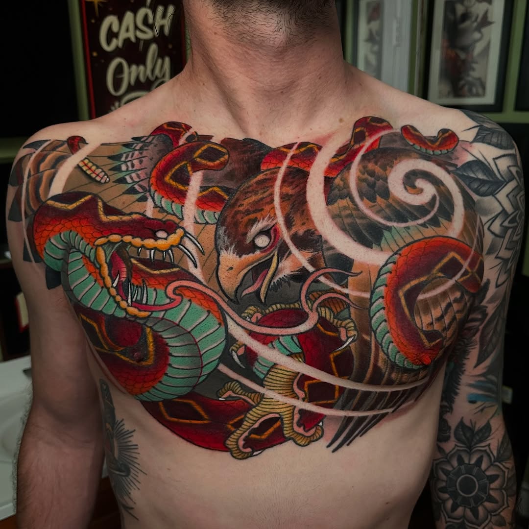 Colorful chest tattoo featuring two intertwined dragons in red, green, and yellow with ornate details and decorative scrollwork across the upper torso.