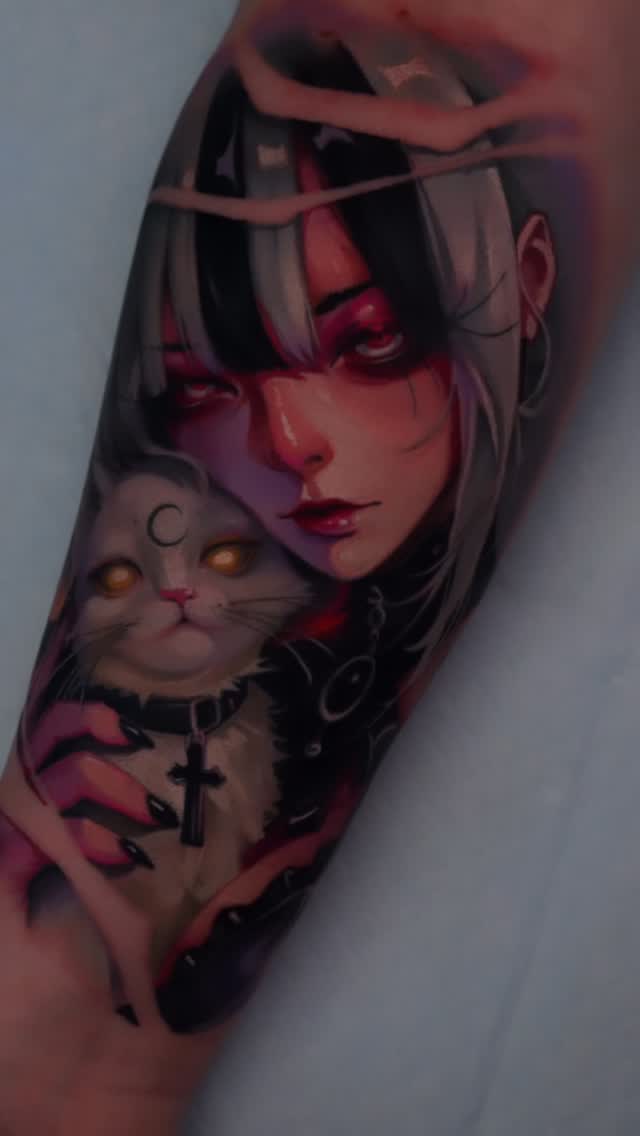Colorful tattoo on forearm featuring a woman with long hair and cat with glowing eyes, accented with crosses and crescent moon symbols.